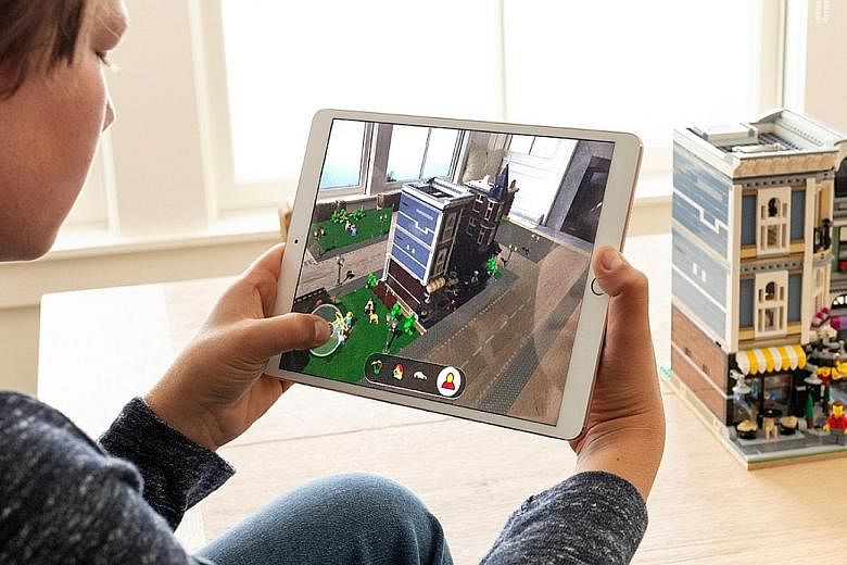 The Lego AR game (above) lets players add a virtual game world to a Lego building, then insert characters and vehicles. Memoji (left) lets users create customised animated emojis.
