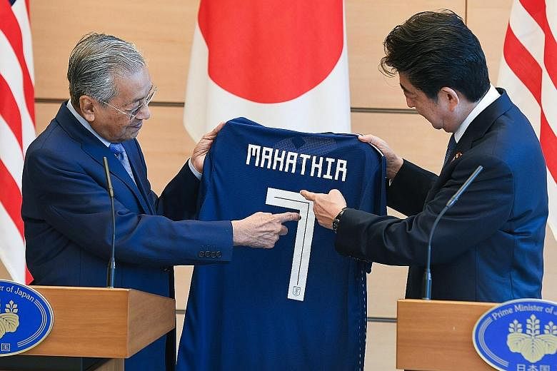 Japanese Prime Minister Shinzo Abe yesterday gave his Malaysian counterpart Mahathir Mohamad a Japan World Cup team jersey with the number 7, to show he is his country's seventh premier.