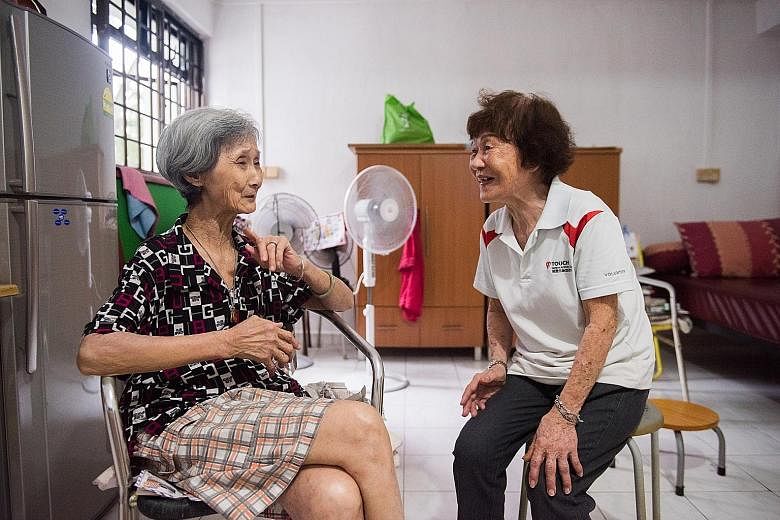 Madam Kok Yoon Hin (right) visiting Madam Teo Chwee Eng at her rented flat. Every Monday, she goes knocking on doors in the Geylang Bahru estate, a routine she has kept to for the past three years.