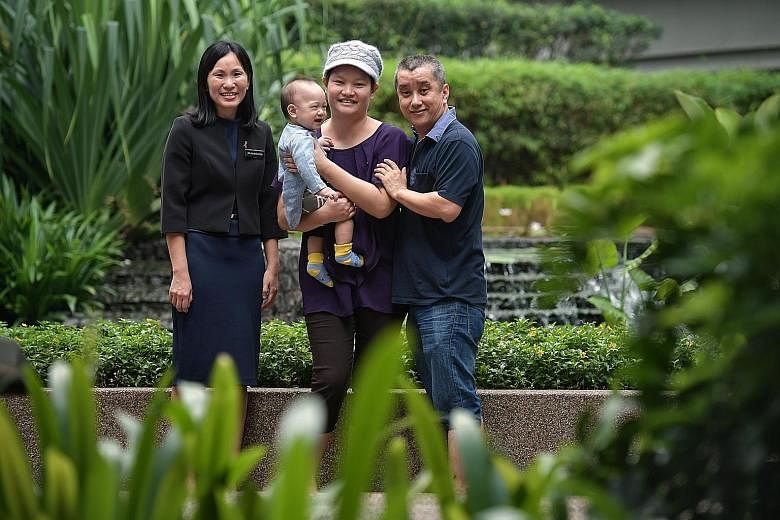 Madam May Wong carrying her 10-month-old son Tok Yuan Yi, with husband Sam Tok Hoe Tooi, 46, and Dr Lim Geok Hoon. Madam Wong underwent the minimal-scar mastectomy 10 days after giving birth to Yuan Yi.