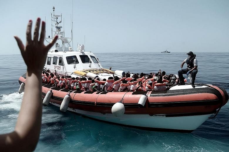 Rescued migrants and humanitarian workers on board an Italian coastguard vessel following their transfer from the French Medecins Sans Frontiers (doctors without borders) ship Aquarius. Relations between France and Italy became strained after French 