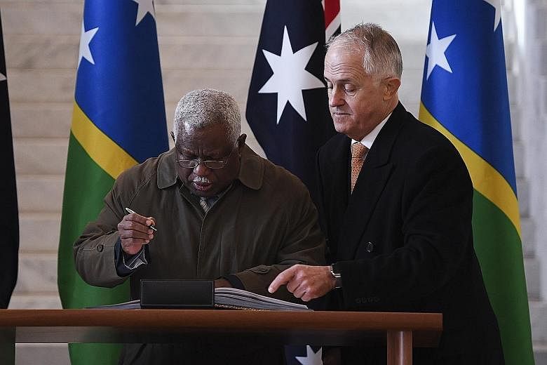 Solomon Islands Prime Minister Rick Houenipwela (left) and Australian Prime Minister Malcolm Turnbull at the signing for the undersea project. The Solomons dropped its deal with China's Huawei after Australia raised concerns.