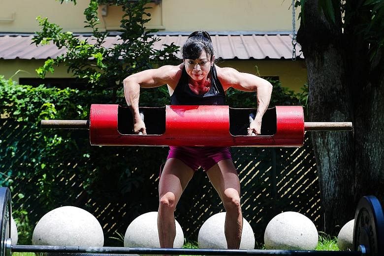Barbara Chng lifting a log as part of her training regimen. The 43-year-old, who is also a mother of twins, won the women's Under-62.5kg category at the World Log and Deadlift Championships on the Gold Coast last month.