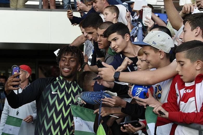 Far left: Nigeria's Alex Iwobi taking selfies with fans at the team's first training session at Essentuki Arena in southern Russia on Tuesday. Left: The German team arriving at Moscow's Vnukovo International Airport on Tuesday. People posing for pict