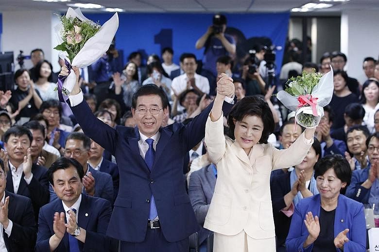 The ruling Democratic Party's Mr Park Won Soon and his wife Kang Nan He celebrating with supporters after he was re-elected mayor of Seoul for a third term on Wednesday.