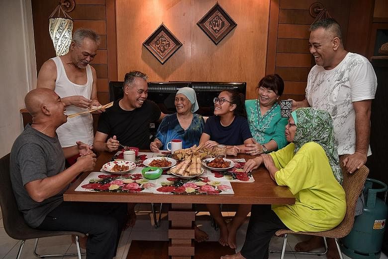 From left: Family members Omar Hashid, 59; Mohd Noor Hashid, 61; Ismail Hashid, 53; Marseah Bonoh, 84; Qurratu'aini Choi Ismail, 14; Nur Qaisarah Alya Choi, 50; Marianah Hashid, 63; and Zulkefli Hashid, 46; taking a break from the cooking yesterday.