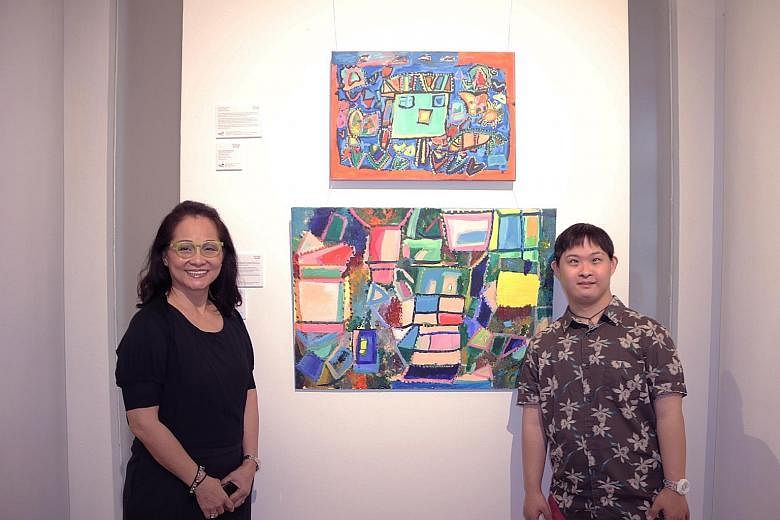Mr Cavan Chang and his mother Cecilia Lai with his pieces at the Rhythm And Water exhibition. The 30-year-old, who has Down syndrome, enjoys creating abstract art and is keen on the new arts programme.