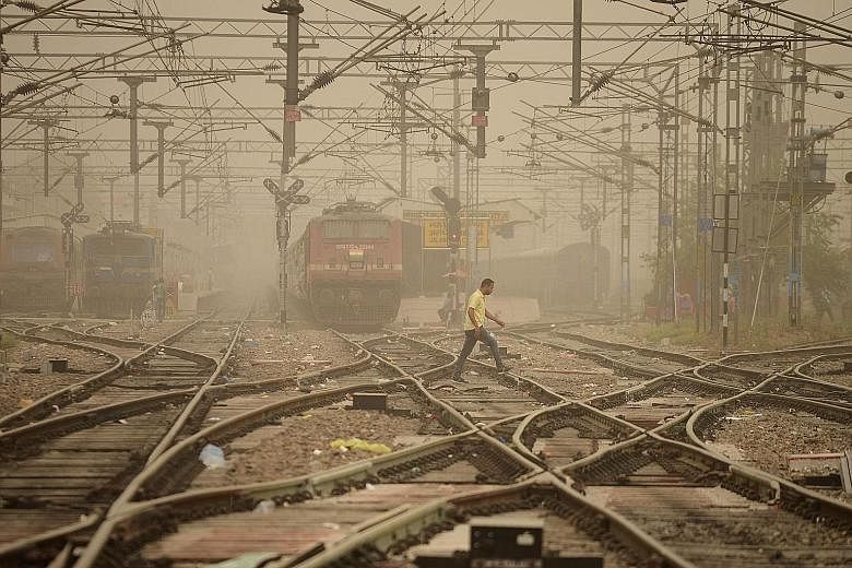 A railway crossing in Jalandhar, India, shrouded in dust yesterday. Meteorologists said dust storms in nearby desert areas had brought dust particles into Delhi. Combined with the existing pollutants in the air, this has resulted in smog-like conditi