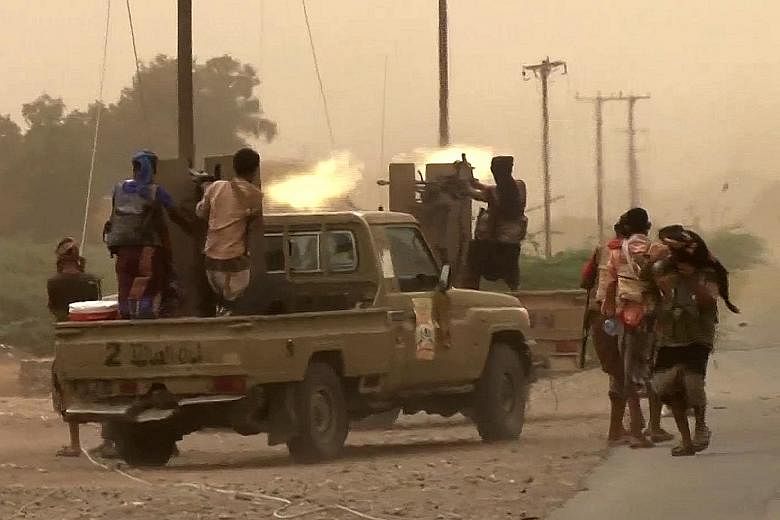 Yemeni pro-government forces firing heavy machine guns at the south of Hodeida airport on Friday. The coalition's ground troops have surrounded the main airport compound but have not seized it, saying they need time to de-mine the area.