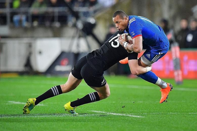 France's Remy Grosso (in blue) is tackled by New Zealand's Jordie Barrett during the second rugby Test between New Zealand and France at Westpac Stadium in Wellington yesterday. New Zealand won 26-13.