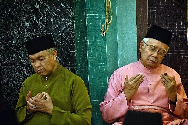 Former deputy prime minister Ahmad Zahid Hamidi and former prime minister Najib Razak performing evening prayers at Umno headquarters in Kuala Lumpur on May 11. Umno has no charismatic leader to replace Mr Najib, who resigned as party president after