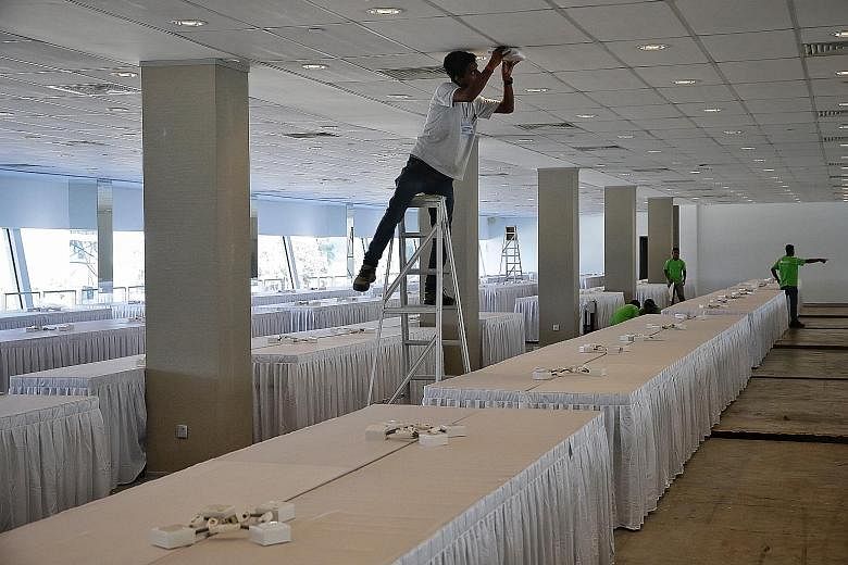 Workers setting up rooms at the F1 Pit Building, which was converted into a media centre for over 2,500 journalists who covered the summit. Mr Kim's decision to visit Marina Bay Sands, Gardens by the Bay and Jubilee Bridge (above) on Monday night was