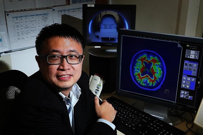 Assistant Professor Thomas Yeo with a magnetic resonance imaging scan of a human brain. The machine can be used to detect tumours or dementia. His main research interests include finding out how different people are vulnerable to mental disorders.