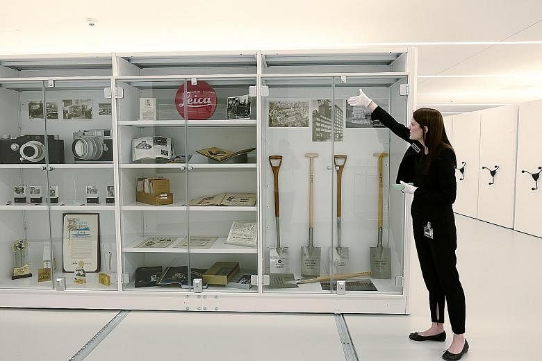 A view from inside the giant "viewfinder" balcony of the new Leica Camera AG building that gives visitors a bird's eye view of the Leitz Park complex. Leica Archive guide Maria-Victoria Furst showing historical items such as shovels used for ground-b