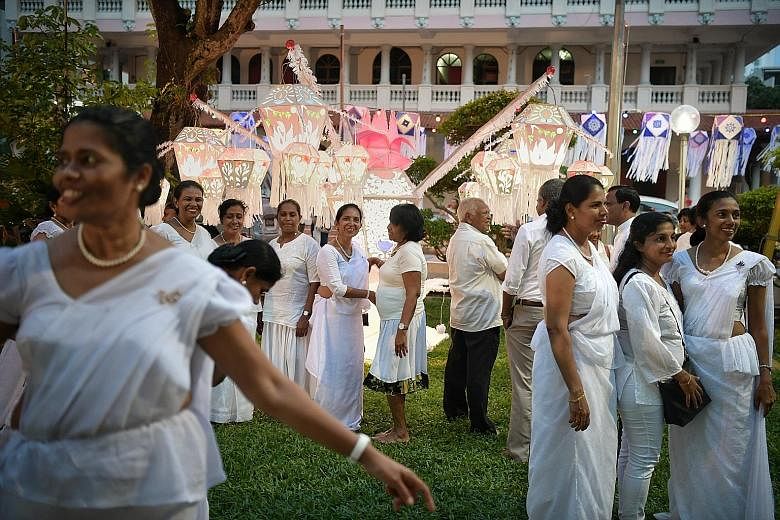 Sri Lankan maids and other guests at Sri Lankaramaya Buddhist Temple on Poson Day yesterday, which marks Buddhism's arrival in Sri Lanka.