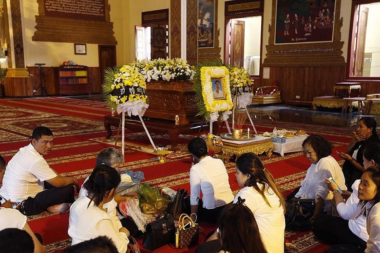 Above: Mourners sitting near a coffin containing the remains of Prince Norodom Ranariddh's wife Ouk Phalla, at a pagoda in Phnom Penh yesterday. Left: Prince Ranariddh and his wife attending a congress in Phnom Penh in January 2015.