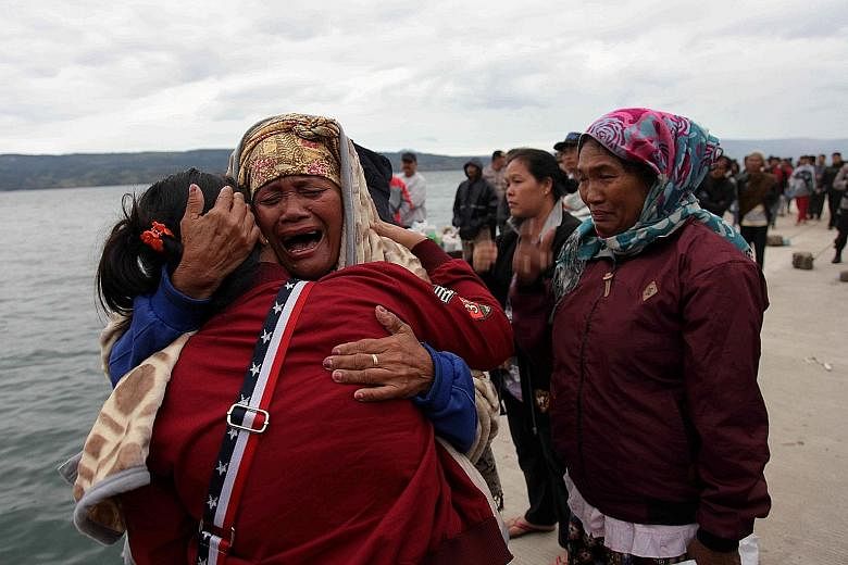 Grief-stricken relatives waiting for news about missing family members who were on a ferry that sank on Monday night in Lake Toba, Sumatra. The Indonesian authorities were trying yesterday to confirm the total number of passengers who had been on boa