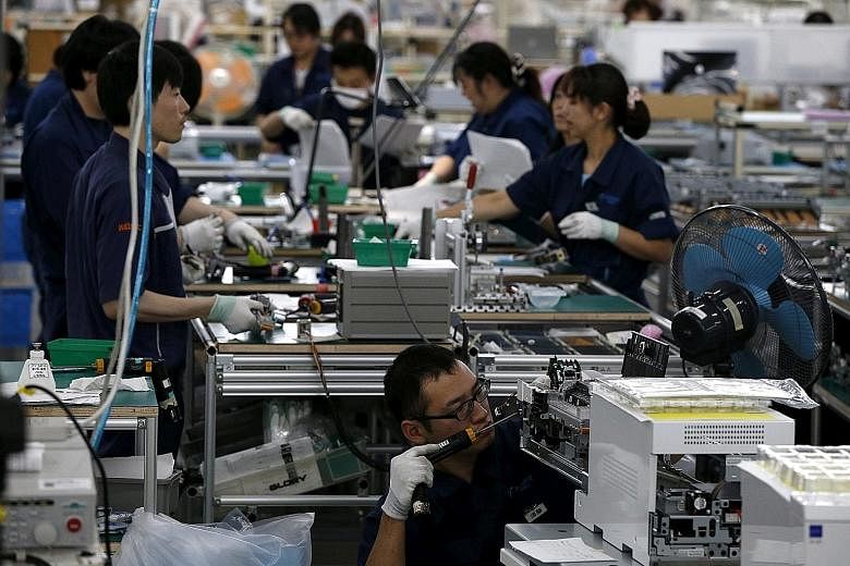 An assembly line at a factory of Glory Limited, a manufacturer of automatic change dispensers, in Kazo, north of Tokyo. Japan manufacturers' confidence is expected to rise over the next three months.
