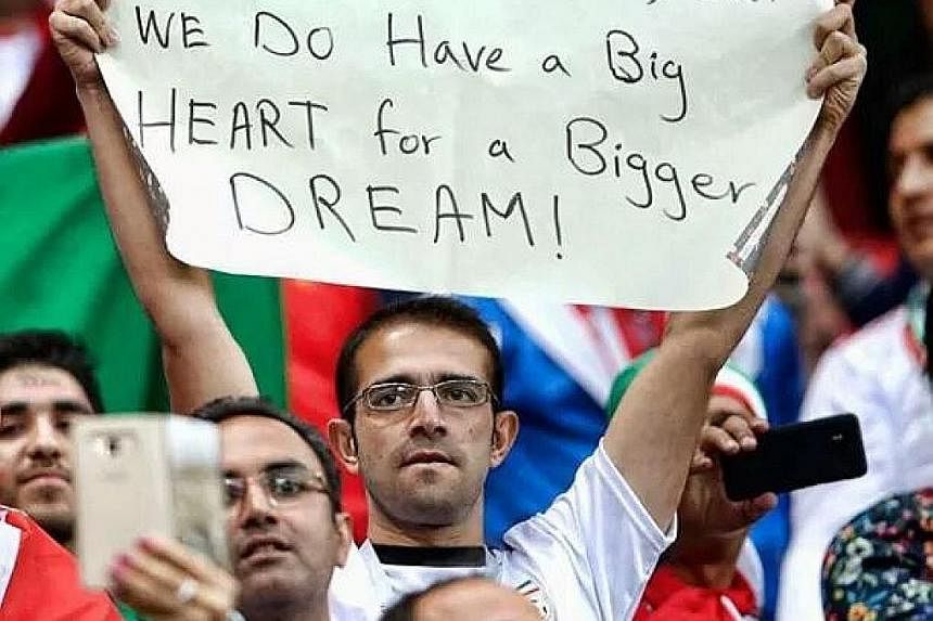 SAY WHAT? "Maybe we do not have Iniesta or Ronaldo, but we do have a Big HEART for a Bigger DREAM!" An Iranian fan getting his message across during his team's 1-0 defeat by Spain. SWEET TWEET Mohamed Salah gets mummified by Uruguay's Diego Godin and