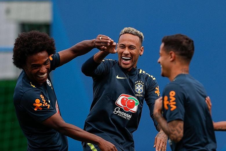 Brazil's Neymar (centre) is all smiles with team-mates Willian and Philippe Coutinho (right). There was cause for concern when he hobbled out of training on Tuesday.
