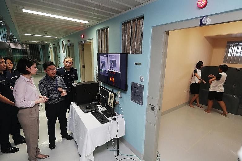 Senior Parliamentary Secretary for Home Affairs and for National Development Sun Xueling watching a demonstration of the prototype video analytics system yesterday, as prison officers simulated a fight between inmates in a cell. The analytics system 