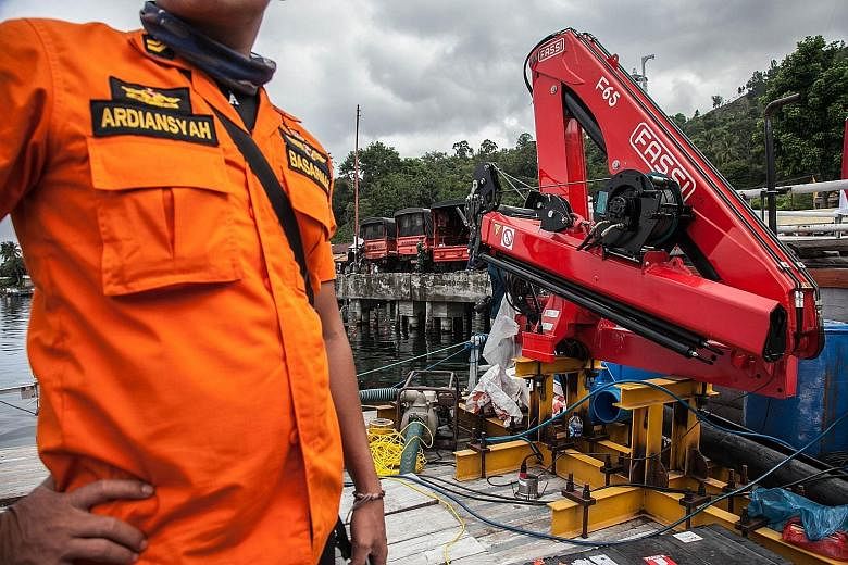 Members of the search-and-rescue team preparing to deploy sonar equipment at the Lake Toba ferry port. A total of 193 people are listed as missing, their bodies believed to be trapped inside the sunken ferry at the bottom of the lake.