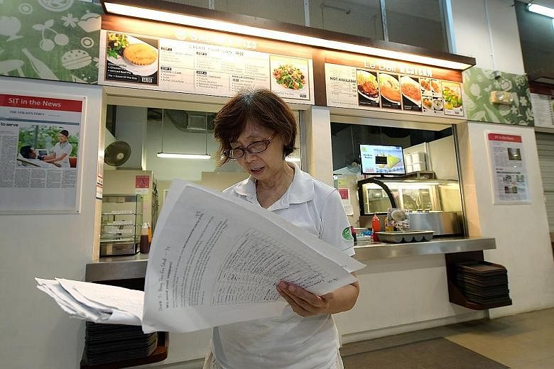 Madam Ong Swee Geok, who runs a salad stall, holding the petition signed by students, staff and other vendors protesting against the rising costs. She was told last month by Food Canopy, which leases out SIT's cafeteria stall spaces, that she would h