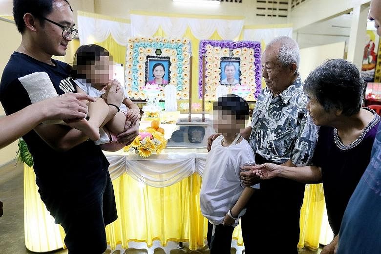 Chua Jun Xian, eight, and sister Xin Rou, five, the children of the couple who died in the crash, with their grandparents, Mr Chua Huat Chuan, 78, and Madam Sii Bee Tee, 69, and another relative at the wake in Seremban.