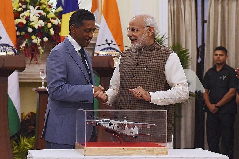 Seychelles President Danny Faure (left) and India's Prime Minister Narendra Modi with a model of a Dornier aircraft.