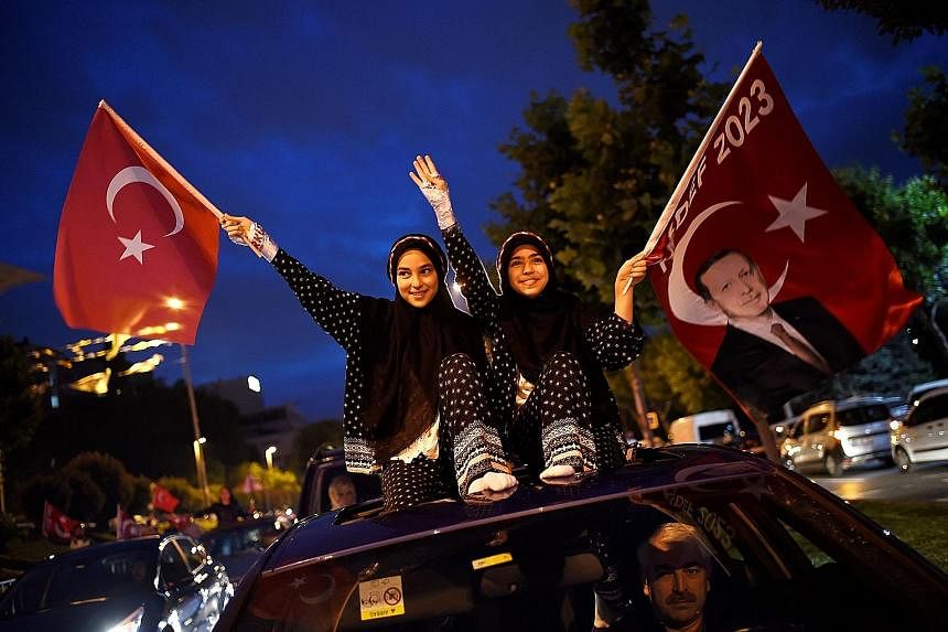 Left: President Recep Tayyip Erdogan greeting his supporters from the balcony of his ruling Justice and Development Party (AKP) headquarters in Ankara, Turkey, on Sunday night. Below left: Supporters waving flags of Mr Erdogan and the AKP outside the