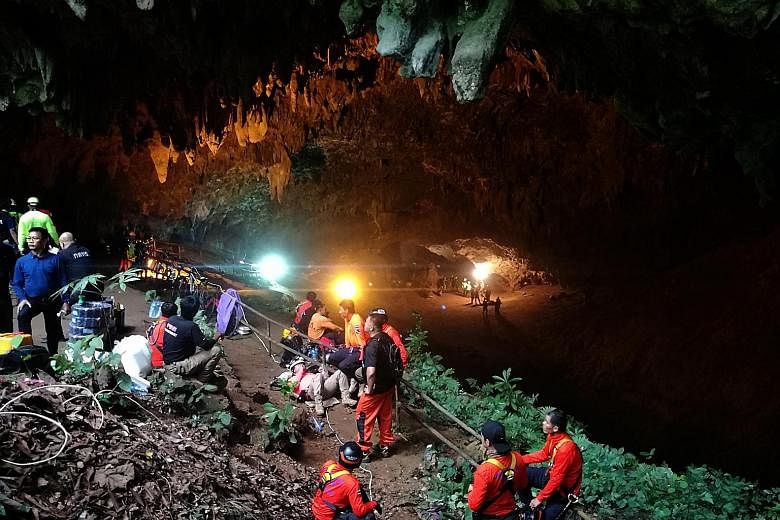 Thai rescue workers and park officials outside the Tham Luang Nang Non cave where 12 football players and their coach have been trapped since last Saturday.