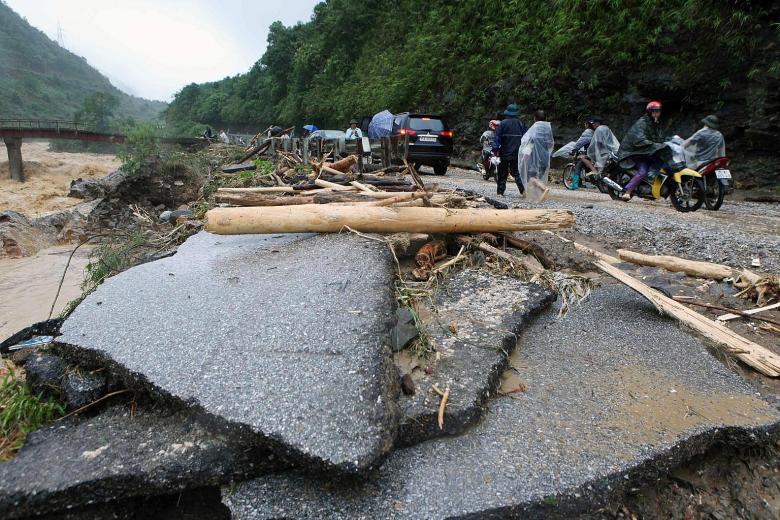 A flood-damaged road in Lai Chau province, Vietnam, on Sunday. At least 12 people were still missing yesterday after weekend floods in the country's mountainous north, and hundreds of police and soldiers have been deployed to help clean-up efforts.