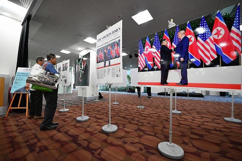 Visitors viewing photos of the Trump-Kim summit taken by ST executive photojournalist Kevin Lim at the National Library Building yesterday.