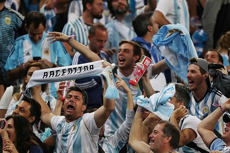 Argentina fans celebrating at St Petersburg Stadium after the winning goal from Marcos Rojo (far left, with captain Lionel Messi, who scored the opening goal) sent the South American side through to the round of 16.