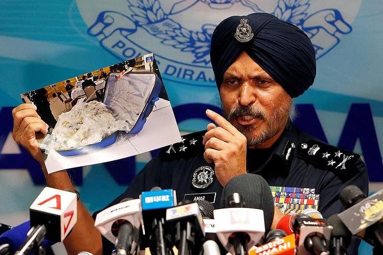 Malaysia's Commercial Crime Investigation Department chief Amar Singh Ishar Singh showing a photo of some of the items seized, at a Kuala Lumpur news conference yesterday.