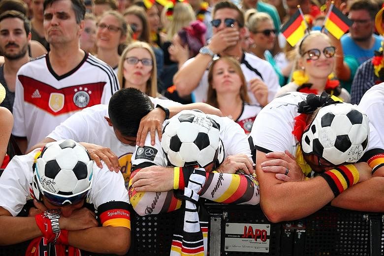 Upset German soccer fans at a public-viewing area at Berlin's Brandenburg Gate as their team lost 0-2 to South Korea on Wednesday. It was the first time since 1938 that Germany has crashed out of the World Cup in the first round.