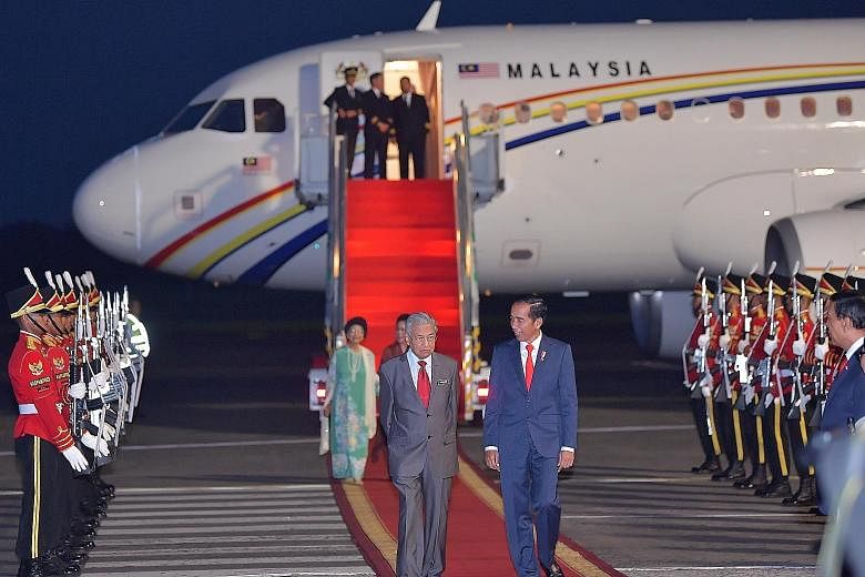 Indonesian President Joko Widodo (right) welcoming Malaysian Prime Minister Mahathir Mohamad at the Halim Perdanakusuma International Airport in Jakarta yesterday. This is Dr Mahathir's first visit to a South-east Asian nation after becoming premier 
