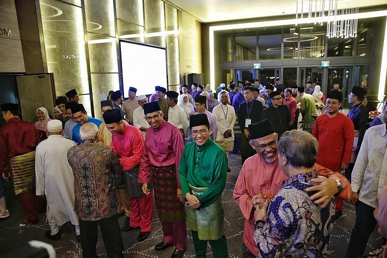 Minister-in-charge of Muslim Affairs Masagos Zulkifli (far right) and fellow ministers welcoming guests during yesterday's Hari Raya gathering at One Farrer Hotel and Spa - the first he was hosting as minister for the Malay/Muslim community.