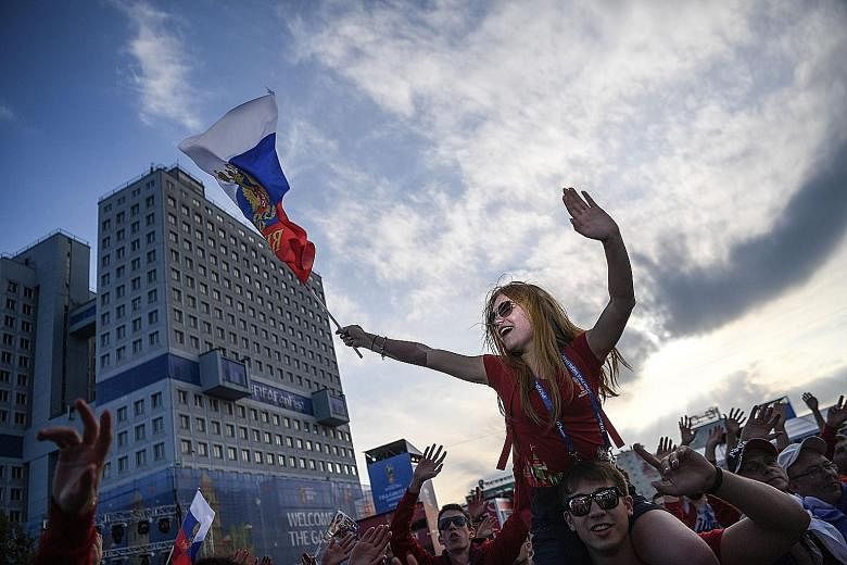 From far left: Local fans cheering on Russia during their Group A match against Egypt against the backdrop of "The Buried Robot". A woman taking a stroll through the "Dancing Forest" or the "Drunken forest", which is some 80km from Kaliningrad's city