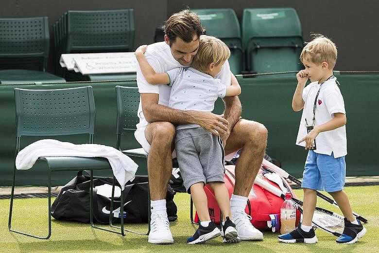 Roger Federer hugging his twin boys, Leo and Lenny, at the end of a training session in Wimbledon on Thursday. The defending champion opens his bid for a record ninth Wimbledon crown by facing Serbia's Dusan Lajovic on Monday.