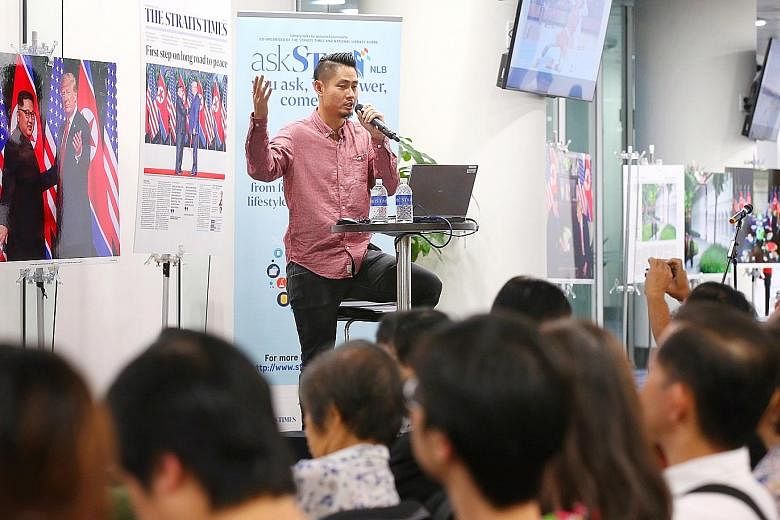Straits Times executive photojournalist Kevin Lim speaking at the askST@NLB session yesterday at the NLB building, where his photos from the June 12 summit were on display.