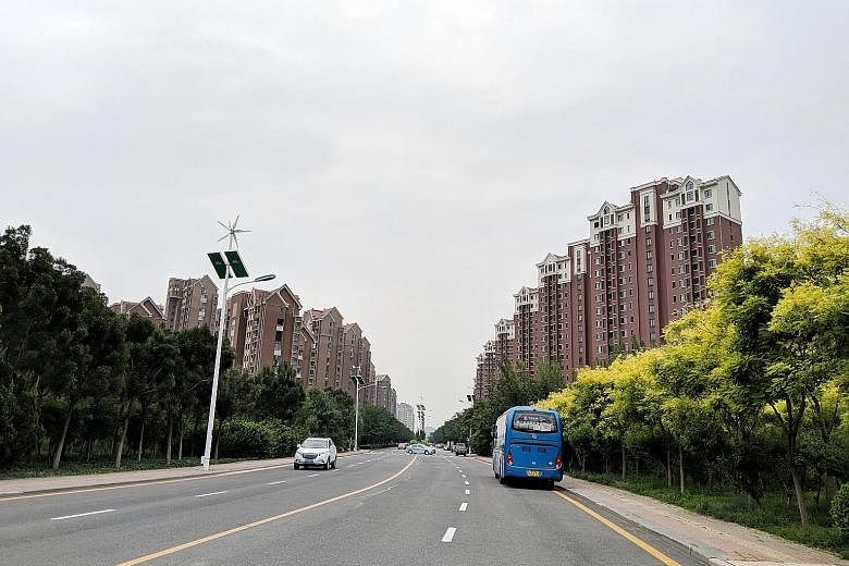 Some lampposts in the Tianjin Eco-city are equipped with wind turbines and solar panels to generate electricity. The eco-city also features housing similar to the HDB blocks seen in Singapore.