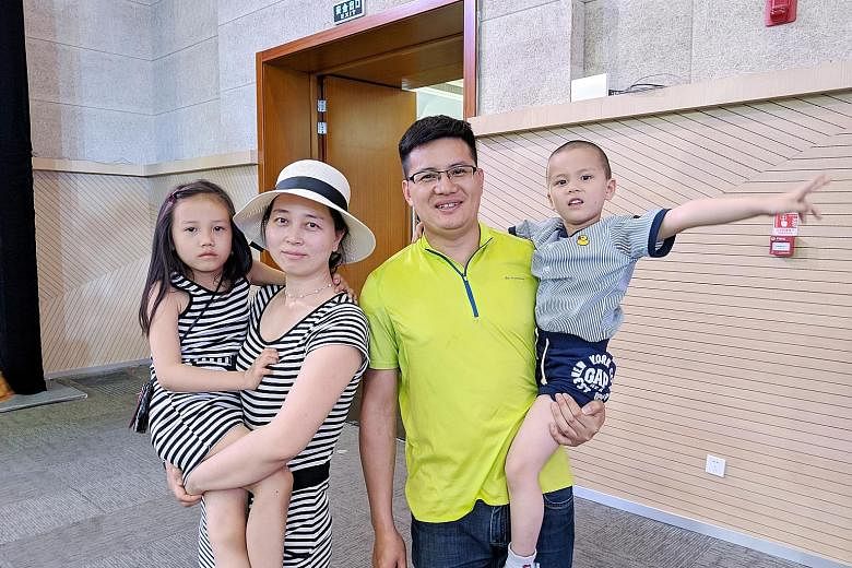 Haematologist Lu Rumin with his wife Zhou Li, 37, and two children at a community event in the Tianjin Eco-city last month. The couple are looking forward to the new amenities in the city, such as the stadium.
