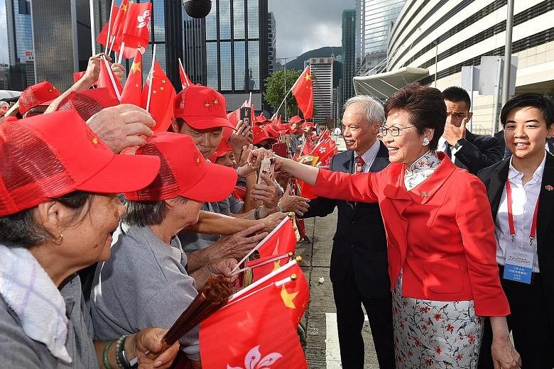 Hong Kong Chief Executive Carrie Lam greeting members of the public before the flag-raising ceremony for the anniversary of the establishment of the Hong Kong Special Administrative Region at Golden Bauhinia Square in Wan Chai yesterday. City residen