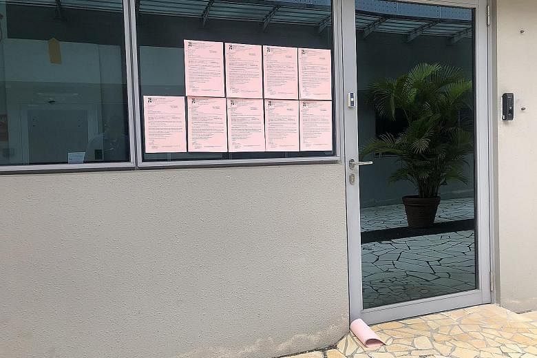 Reminder notices for fines pasted on the windows of oBike's office.