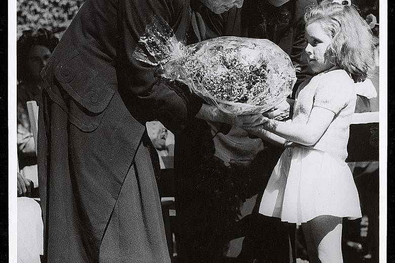 A child presenting a bouquet to Helen Keller, who visited more than 39 countries in her lifetime and did advocacy work.
