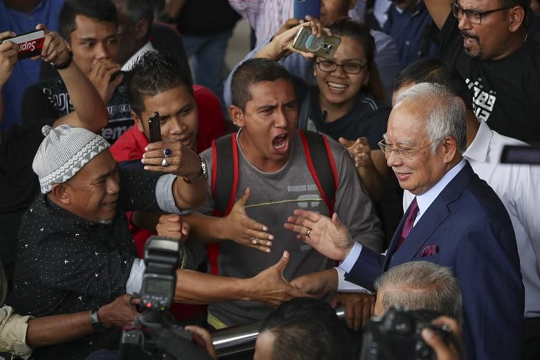 Former Malaysian prime minister Najib Razak being greeted by his supporters as he left the court in Kuala Lumpur yesterday. Najib pleaded not guilty to four charges levelled against him in relation to funds linked to SRC International, a former subsi
