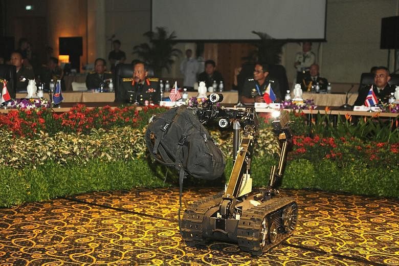 A Talon Unmanned Ground Vehicle removing a suspicious bag during a demonstration by the SAF's CBRE Defence Group at the workshop.