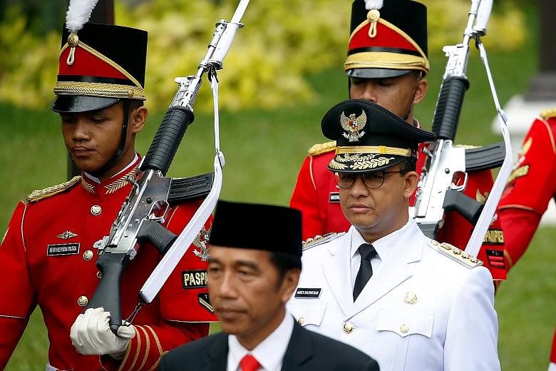 Indonesian President Joko Widodo with Jakarta Governor Anies Baswedan (in white) at Mr Anies' swearing-in ceremony in Jakarta last October. Voting for Indonesia's next president will take place on April 17 next year.