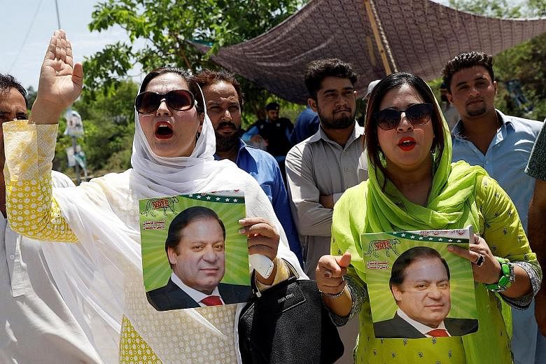 Supporters of the PML-N party, with pictures of former prime minister Nawaz Sharif, rallying against the verdict against him in Islamabad yesterday. His daughter and her husband were also given jail sentences.